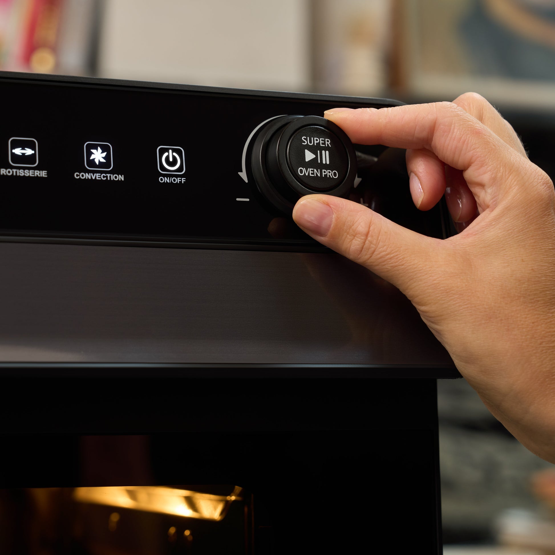 A hand turns a dial on the Fridja f77 Super Oven Pro - 30L Digital Air Fryer Oven, showing buttons labeled “Rotisserie,” “Convection,” and “On/Off” on its sleek control panel.