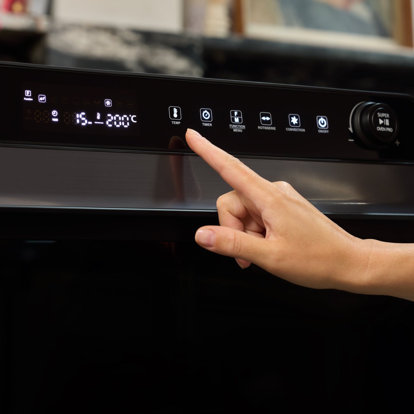 A hand presses a button on the Fridja f77 Super Oven Pro 30L Digital Air Fryer Oven’s control panel, with icons and a display showing 200°C and 55 minutes.