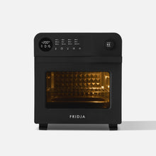 The Fridja f66 Super Oven is a black 15L digital air fryer oven with a display, control buttons, a knob, and a glass door revealing an illuminated interior. It features convection cooking for even results. The Fridja brand is printed at the bottom.