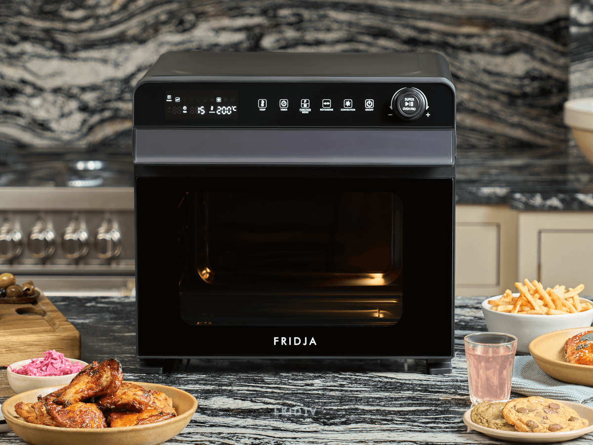Fridja Super Oven air fryer oven with roasted dishes on a marble counter