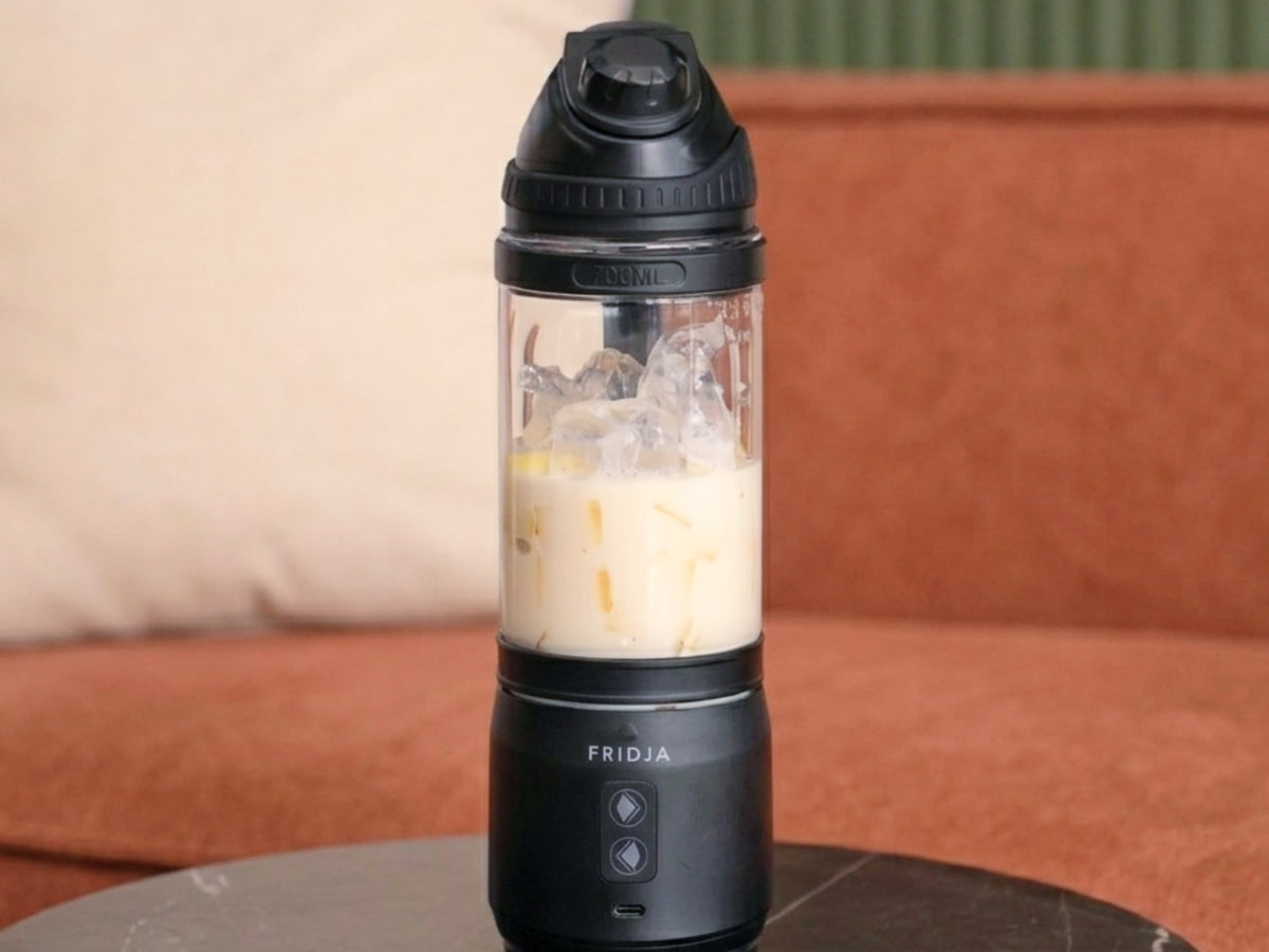 Fridja f500 portable blender with a creamy smoothie on a marble side table